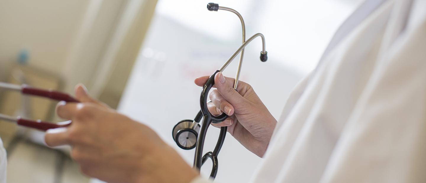 A person's hand holding a stethoscope.